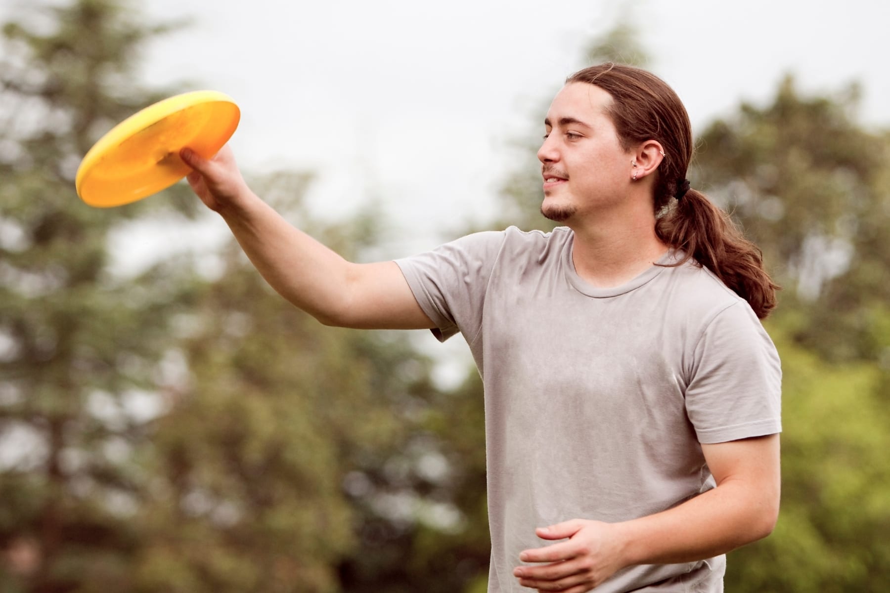 A man holding a yellow frisbee.