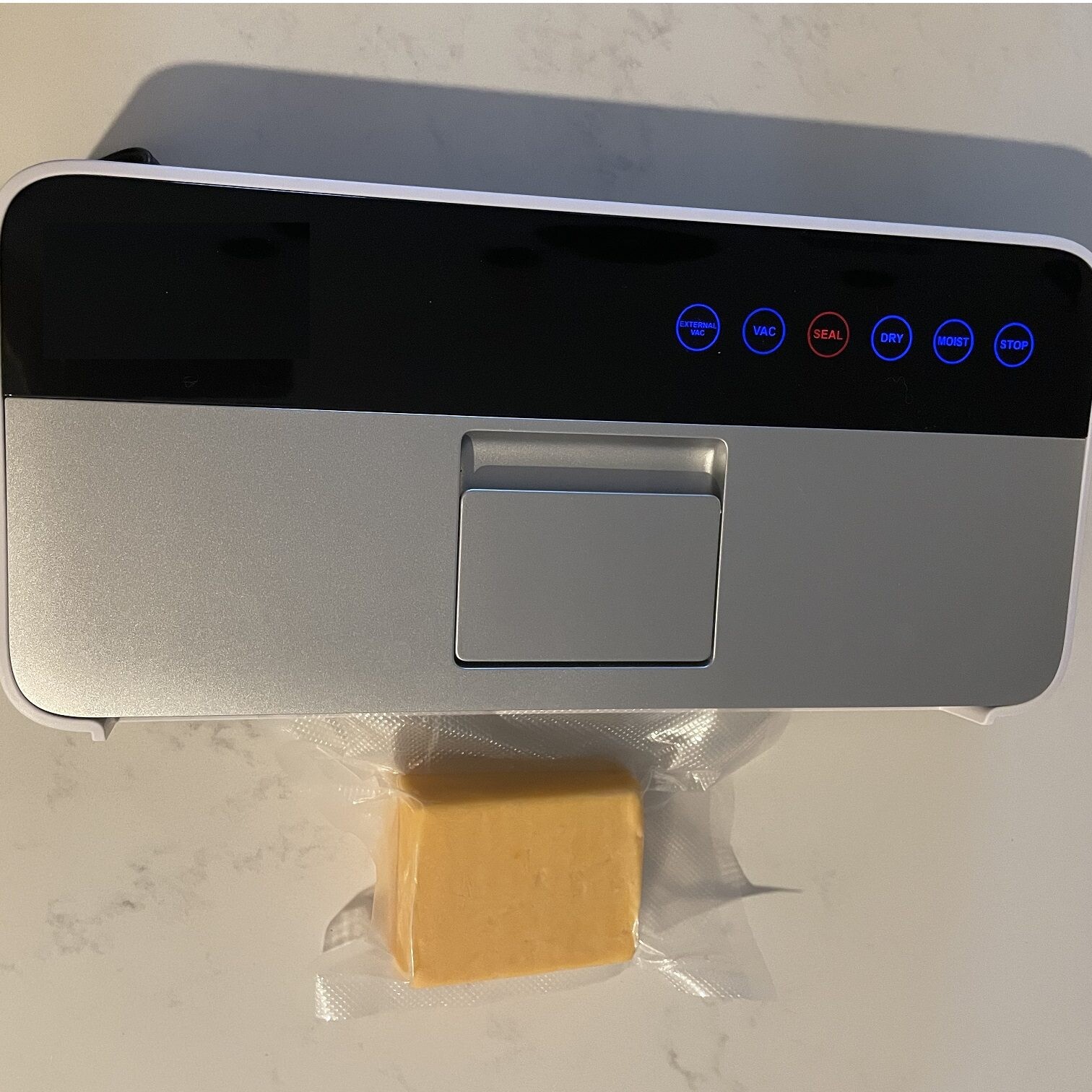 A vacuum sealer sealing up a block of cheese