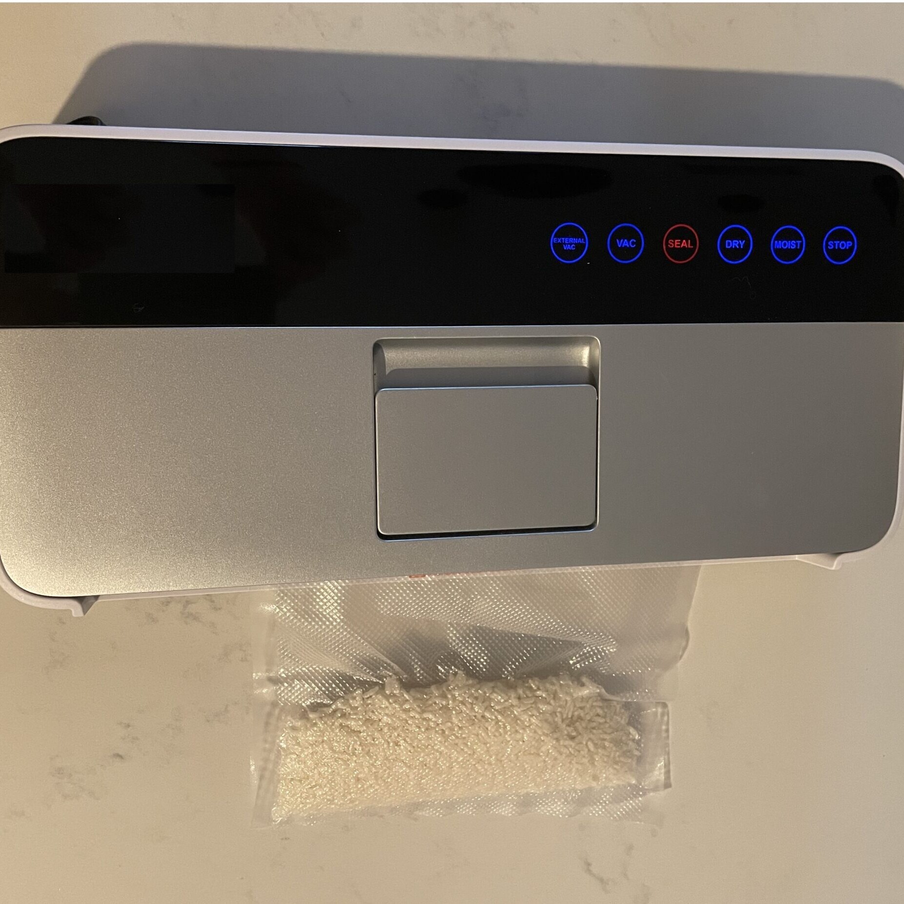A vacuum sealer sealing a bag of rice
